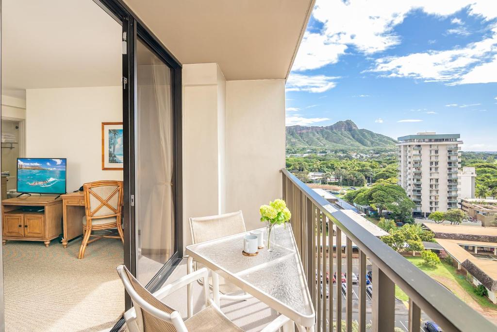 a balcony with a table and chairs and a desk at Cozy & Diamond Head View at Waikiki with Parking in Honolulu