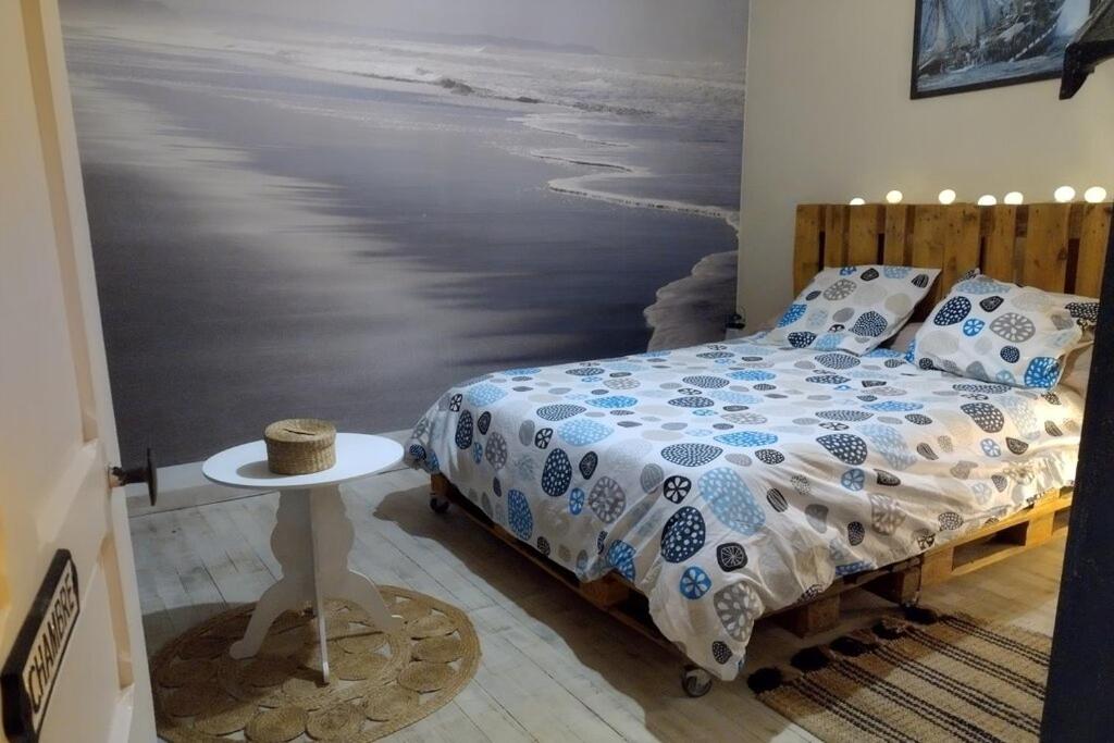 - une chambre avec un lit et une peinture sur l'océan dans l'établissement Le gite des galopins, à Saint-Just