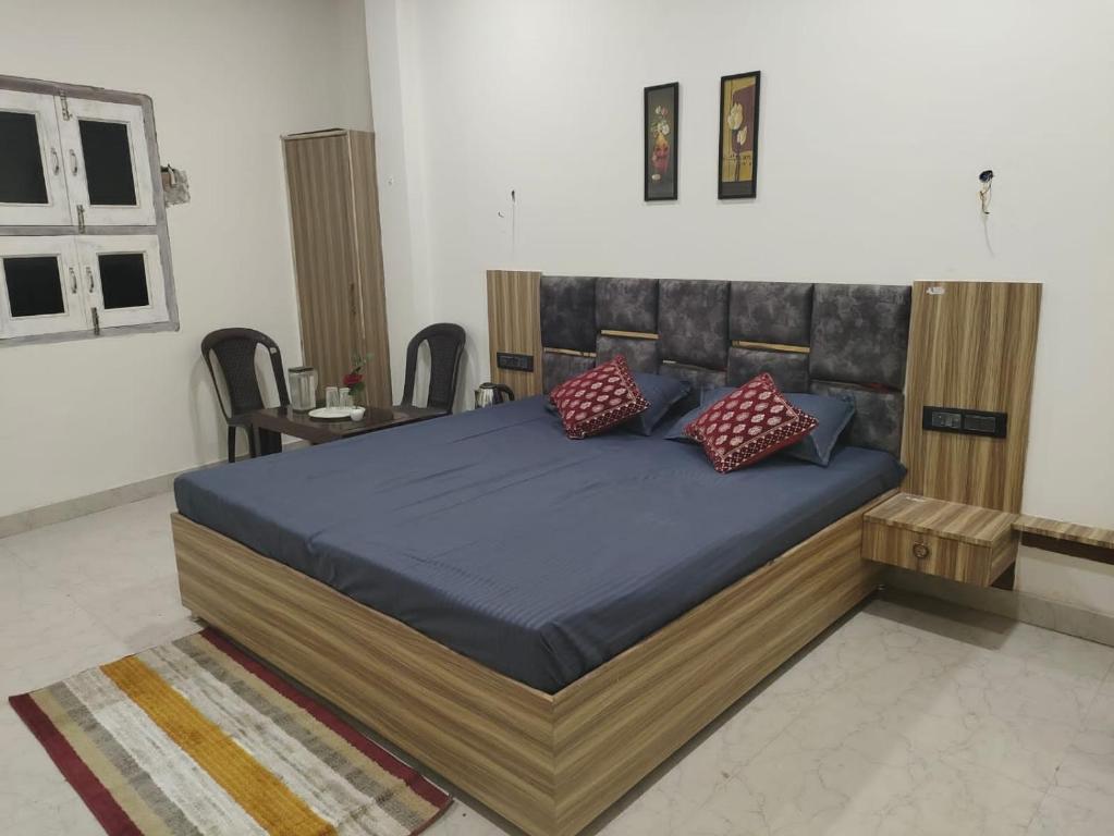 a bedroom with a large bed with blue sheets and red pillows at Varanasi homestay in Varanasi