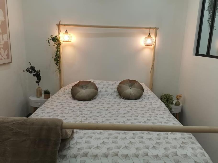 une chambre avec un lit avec deux oreillers dessus dans l'établissement L’Impérial au RDC, à Douai