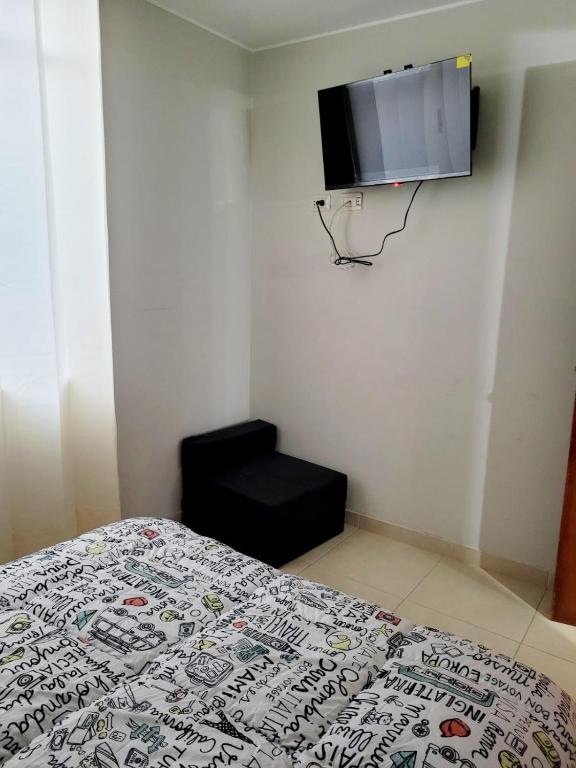 ein Schlafzimmer mit einem Bett und einem TV an der Wand in der Unterkunft VILLA HUARANGOS in Ica