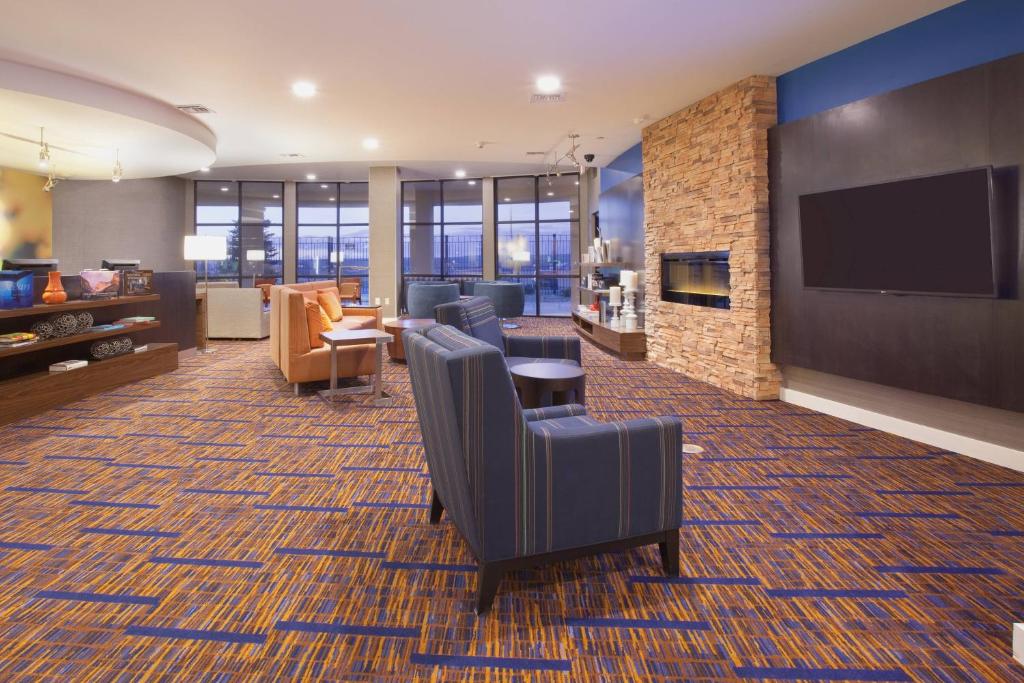 a lobby with chairs and a flat screen tv at Courtyard Casper in Casper