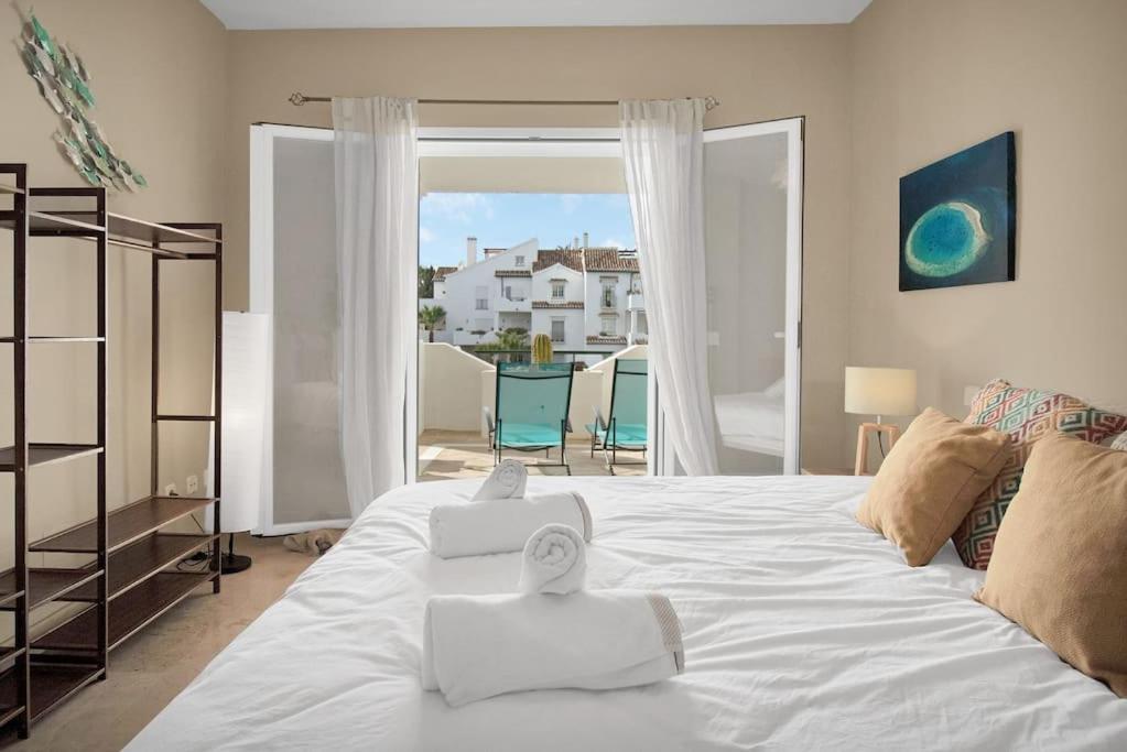 sypialnia z dużym białym łóżkiem i balkonem w obiekcie Apartamento en complejo con piscina climatizada - EL PRESIDENTE 234 w mieście Estepona