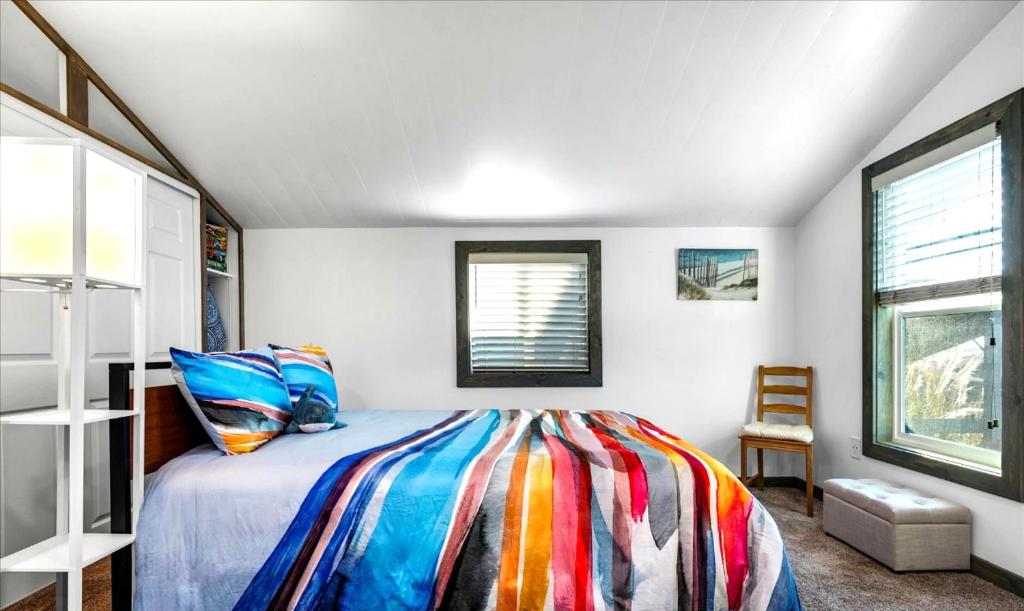 a bedroom with a bed with a colorful blanket at Sonoma Coast Retreat - Water Views BBQ WIFI in Bodega Bay