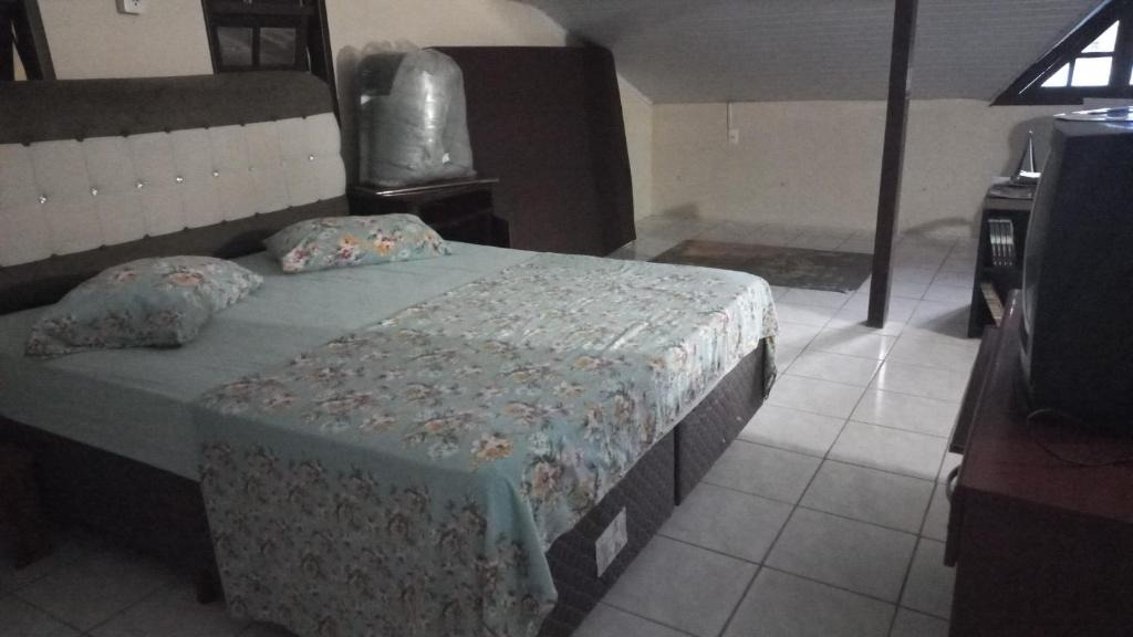 Recanto dos pássaros في بومبينهاس: غرفة نوم بسرير كبير عليها مخدات