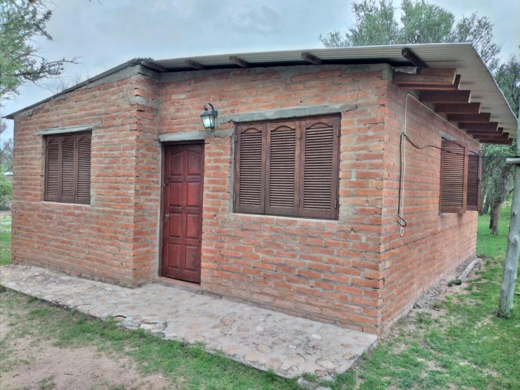 a small brick building with a door and windows at La Vuelta del Río in Panaholma