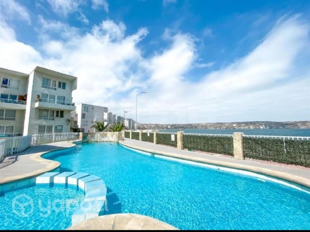 a swimming pool with a view of the water at Arriendo la herradura in Coquimbo