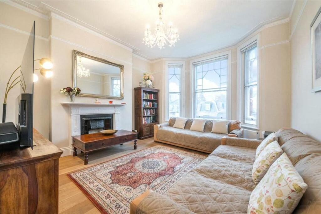 a living room with a couch and a fireplace at Stylish flat in Hampstead in London