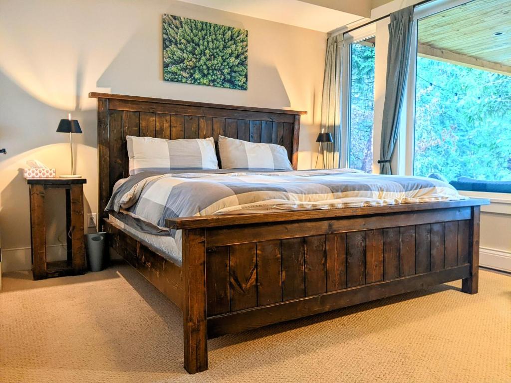 Un dormitorio con una gran cama de madera y una ventana en Mountain House of Wonder, en Qualicum Beach