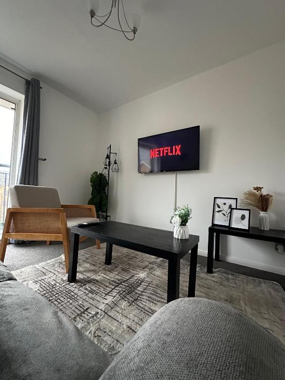 a living room with a tv on the wall at Timber Court - 2 free parking spaces - 2 Bedroom Apartment - Fast Wi-Fi - Perfect for Long Term - by Rockman Residences in Stifford