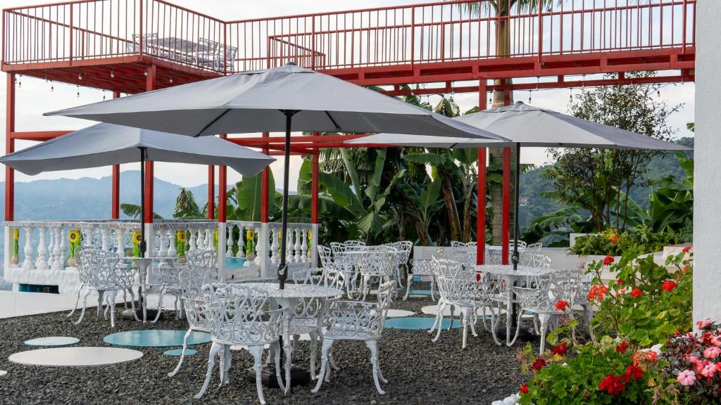 un grupo de mesas y sillas con sombrillas en BALCÓN DEL CIELO eco hotel glamping, en Frailes