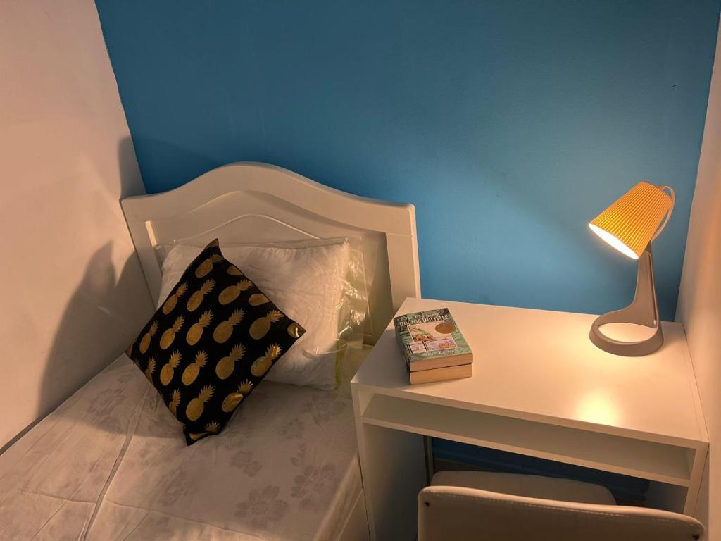 a bed with a pillow and a table with a lamp at Bachelor Partition Room in Tecom in Dubai