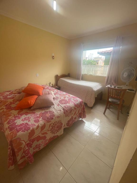- une chambre avec un lit, une fenêtre et une chaise dans l'établissement Apartamento 1 quarto 400m da praia de Taperapuan, à Porto Seguro
