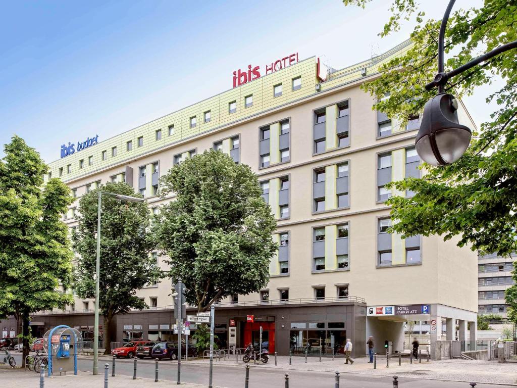 un gran edificio blanco con un cartel. en ibis Berlin Kurfuerstendamm en Berlín