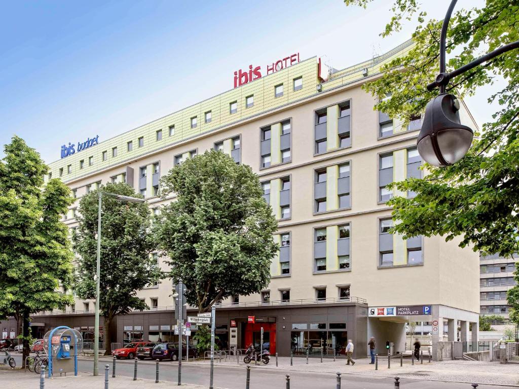 um grande edifício branco com um cartaz em ibis Berlin Kurfuerstendamm em Berlim