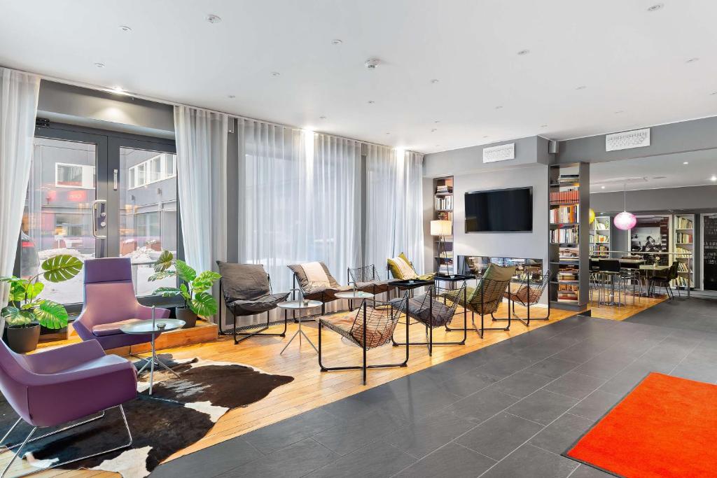 een woonkamer met stoelen en tafels en een televisie bij Aiden by Best Western Stockholm Kista in Stockholm