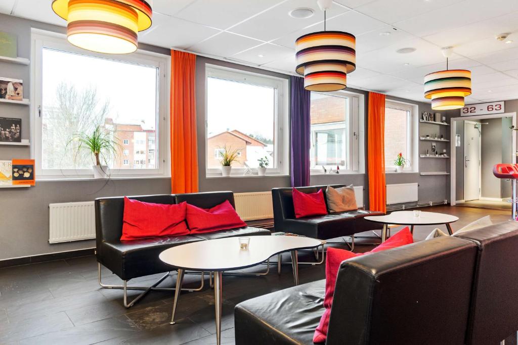 uma sala de espera com sofás, mesas e janelas em Sure Hotel by Best Western Stockholm Alvsjo em Estocolmo
