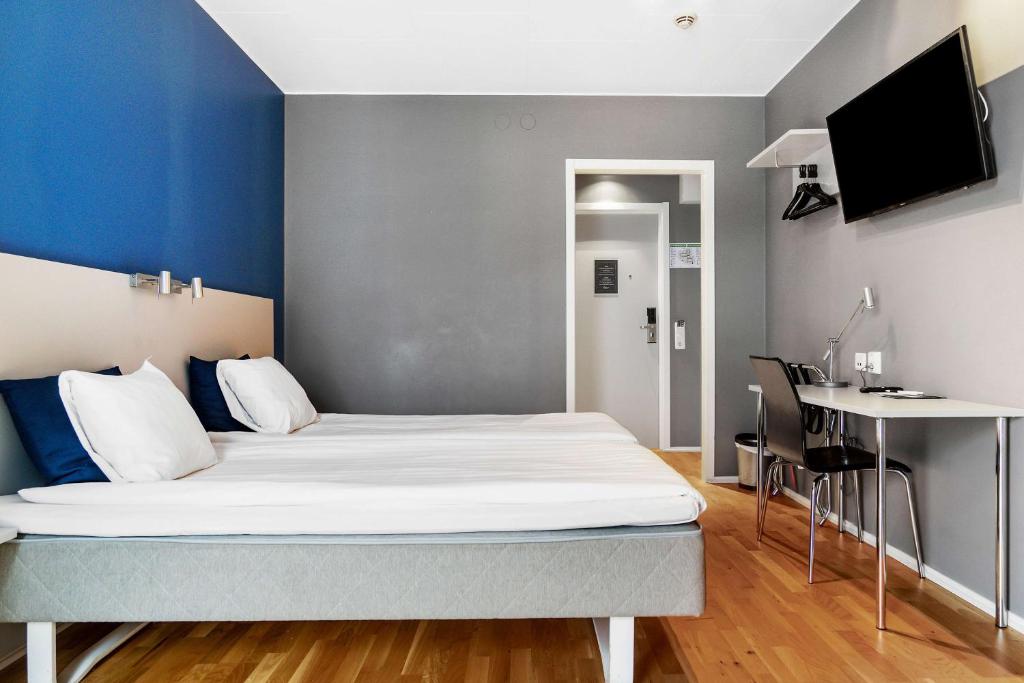 a bedroom with a bed with a blue wall at Sure Hotel by Best Western Stockholm Alvsjo in Stockholm