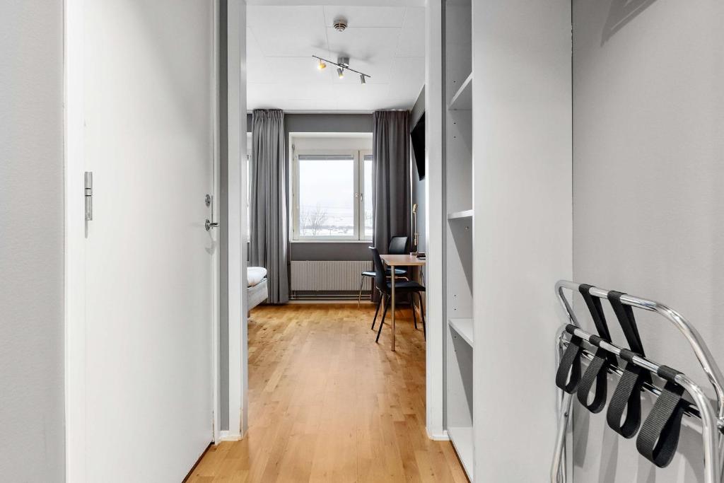 a hallway with a room with a table and chairs at Sure Hotel by Best Western Stockholm Alvsjo in Stockholm
