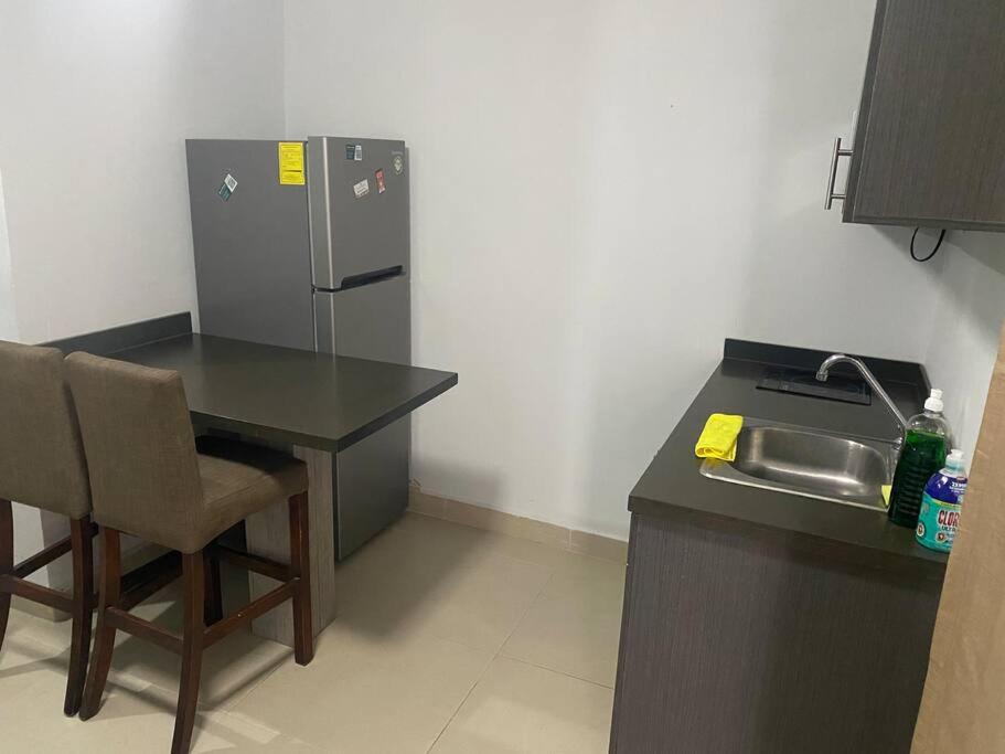 a small kitchen with a table and a refrigerator at Alojamiento completo de descanso in Monterrey