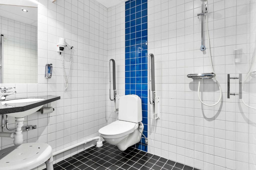 a bathroom with a shower and a toilet and a sink at Sure Hotel by Best Western Stockholm Alvsjo in Stockholm