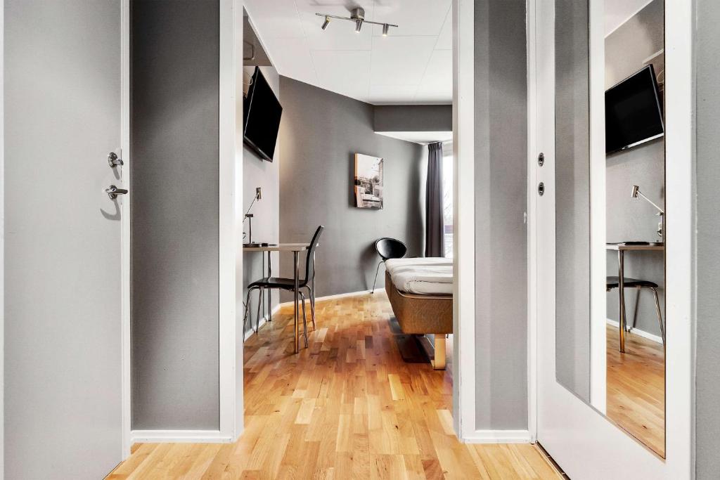 a hallway with a room with a bed and a table at Sure Hotel by Best Western Stockholm Alvsjo in Stockholm
