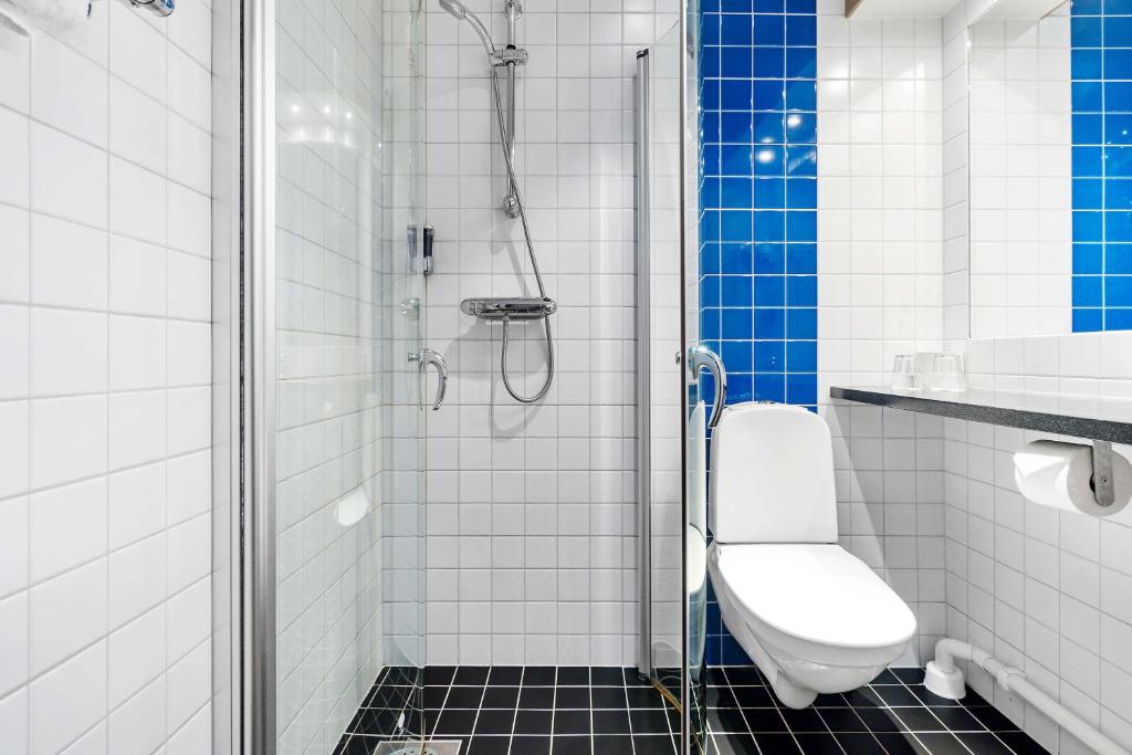 a bathroom with a shower with a toilet and a sink at Sure Hotel by Best Western Stockholm Alvsjo in Stockholm