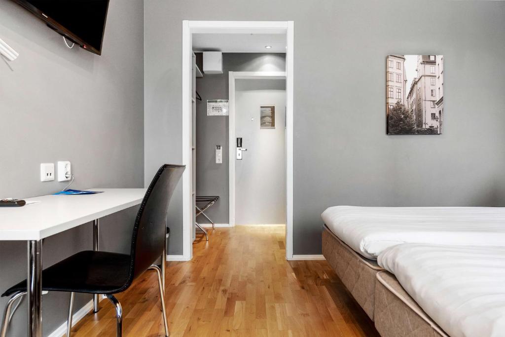 a bedroom with a bed and a desk and a desk and chair at Sure Hotel by Best Western Stockholm Alvsjo in Stockholm