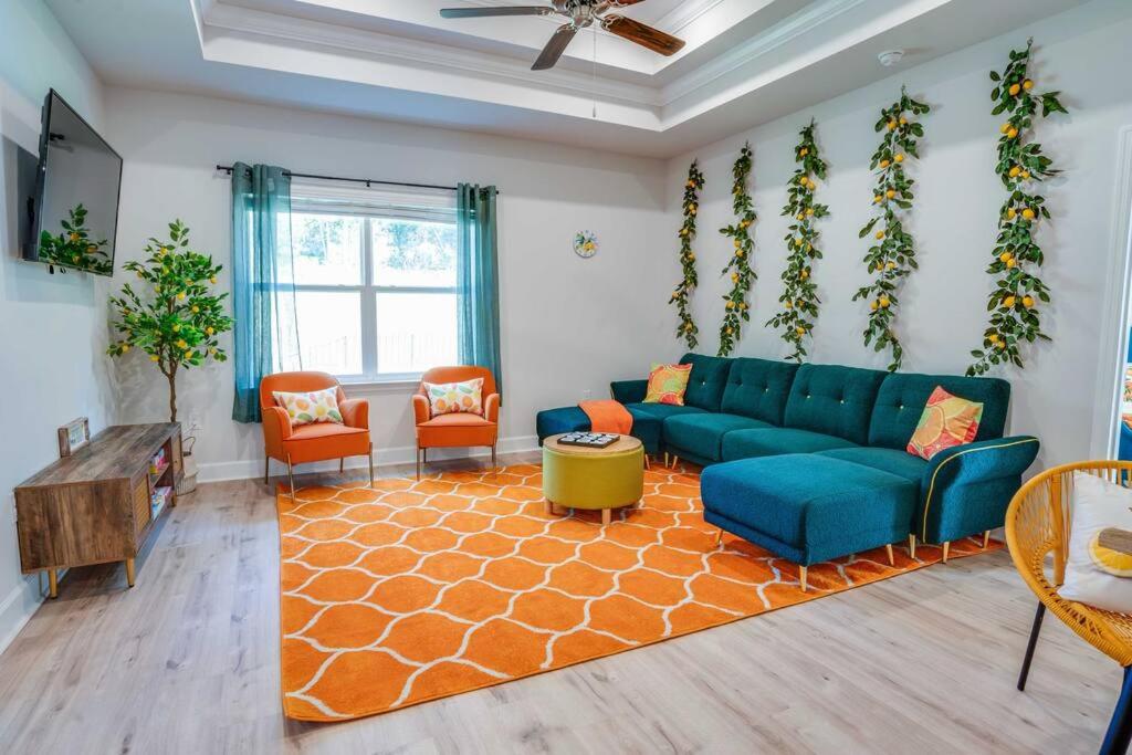 a living room with a blue couch and orange chairs at Citrus Cottage: Comfy - Hwy 10 - Peaceful Retreat in Tallahassee