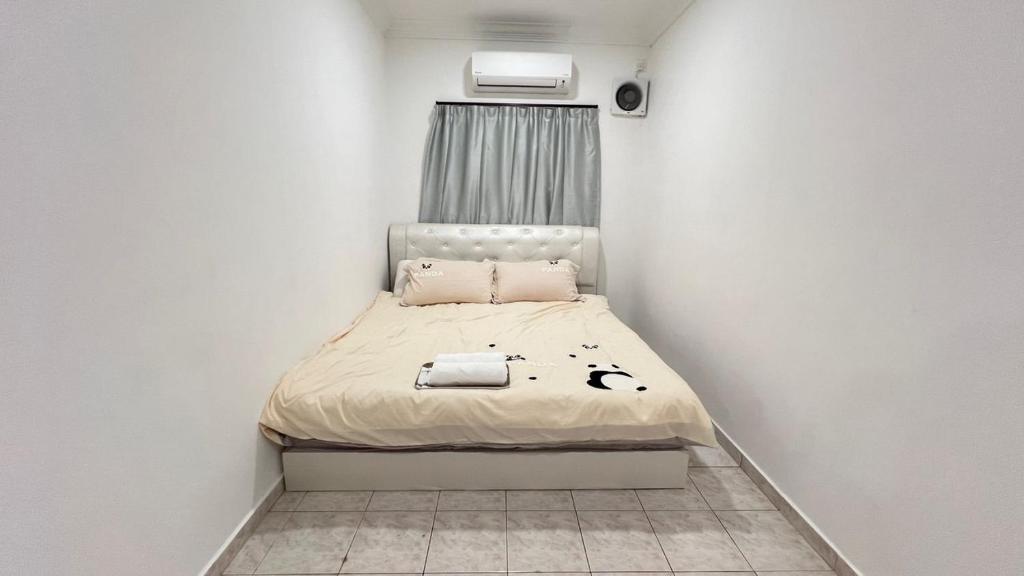 PandaHomestay28 في سكوداي: غرفة نوم صغيرة مع سرير في غرفة بيضاء