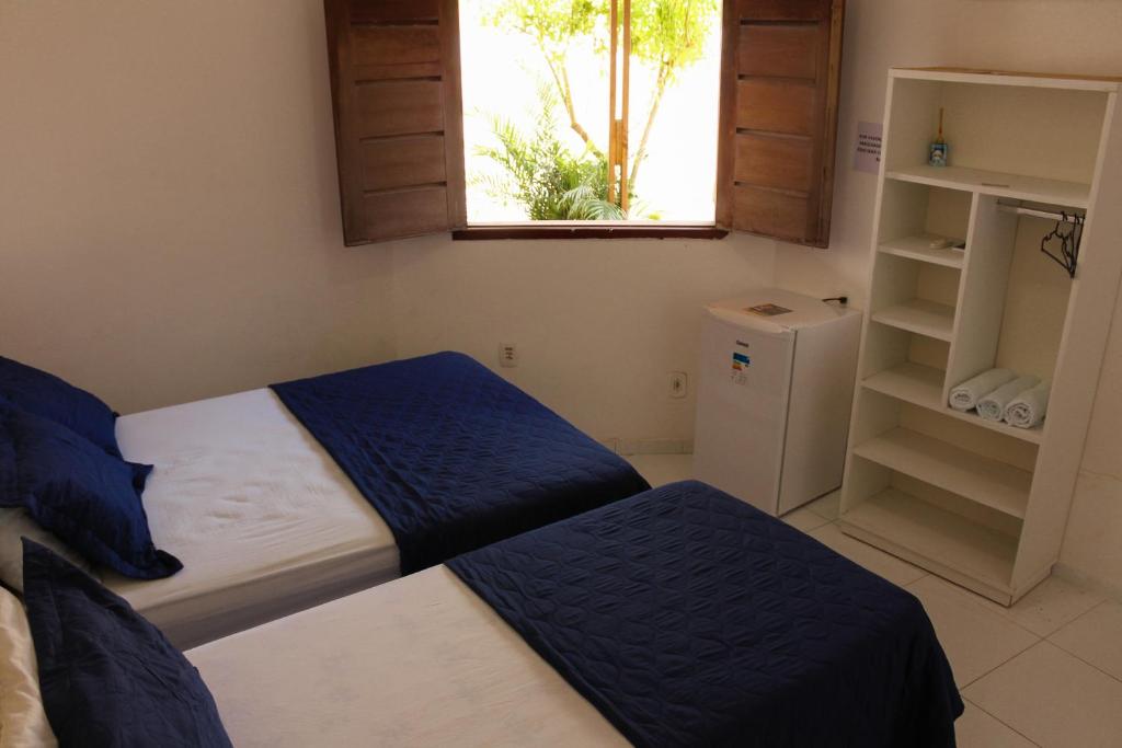 a bedroom with two beds and a window at Hotel Mandacaru in Piranhas