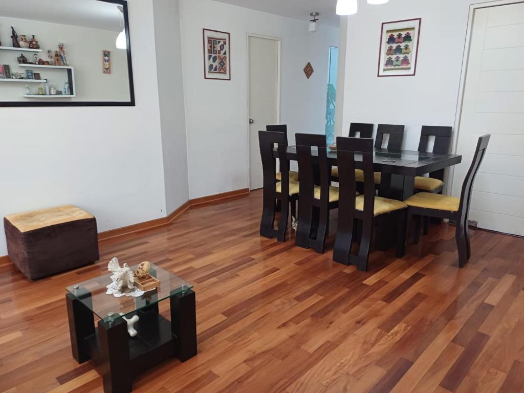 comedor con mesa negra y sillas en Habitación acogedora Aramburú, en Lima