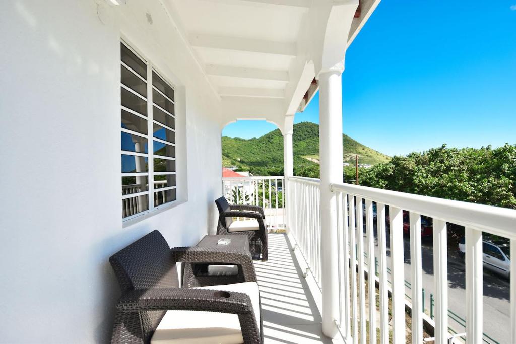 - une terrasse couverte avec 2 chaises et une vue sur l'océan dans l'établissement Balconies at Grand Case, à Grand-Case