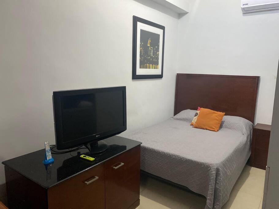 una camera con letto, TV e letto gmaxwell gmaxwell gmaxwell di Loft hermoso con estacionamiento gratuito a Monterrey