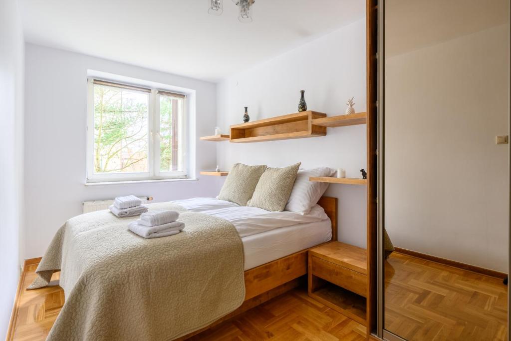 Schlafzimmer mit einem Bett mit weißer Bettwäsche und einem Fenster in der Unterkunft Bella Casa Premium Apartment - Biesiadna - Warszawa in Warschau