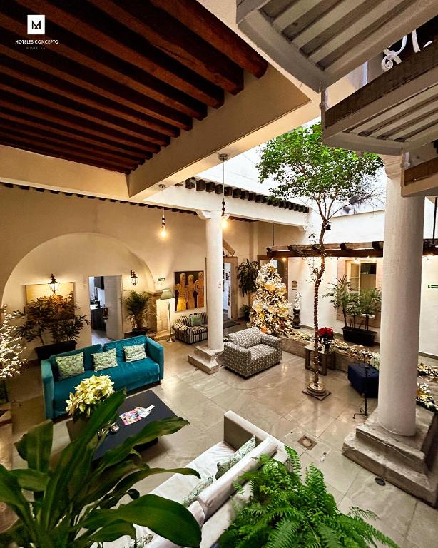 an outdoor living room with blue couches and plants at M Hoteles Concepto in Morelia