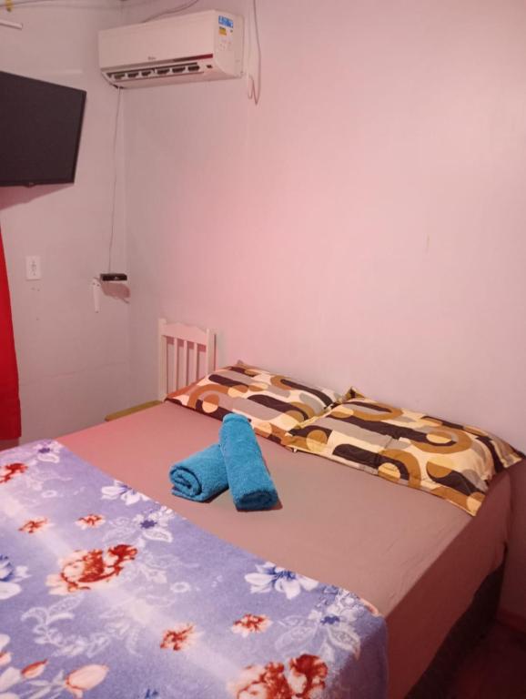 2 camas individuales en un dormitorio con toallas azules en Aconchego, en Pântano Grande