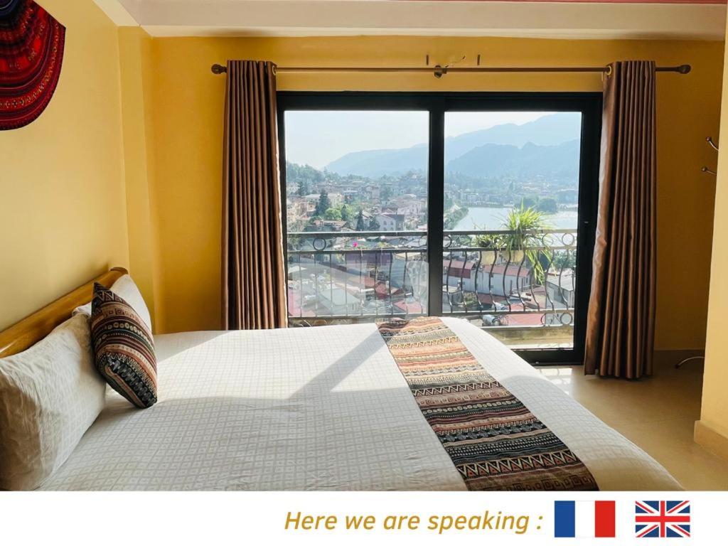 a bedroom with a bed and a large window at Happy Family Hotel in Sa Pa