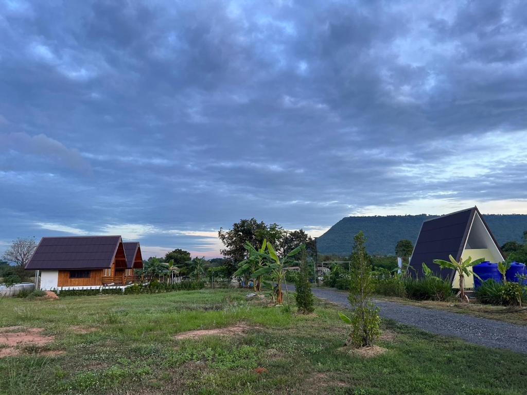 a group of houses in a field next to a road at สวนเบอร์รีแคมป์ทนายจุฬา Berry Camp Korat in Ban Nong Khon