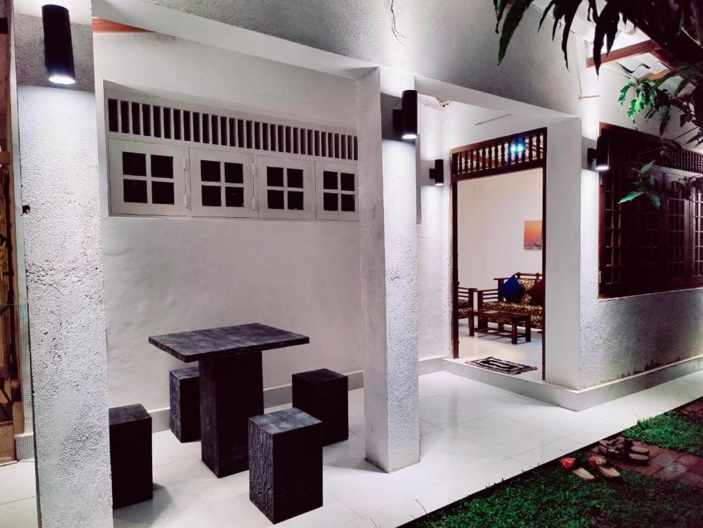 um quarto com uma mesa e bancos numa casa em Araliya Uyana Residencies Colombo - Entire House with Two Bedrooms em Colombo
