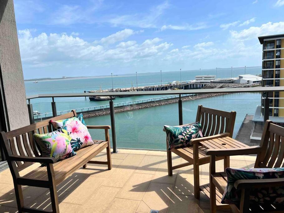 balcón con 2 bancos y vistas al océano en Sea Pearl Apartment at Waterfront, en Darwin