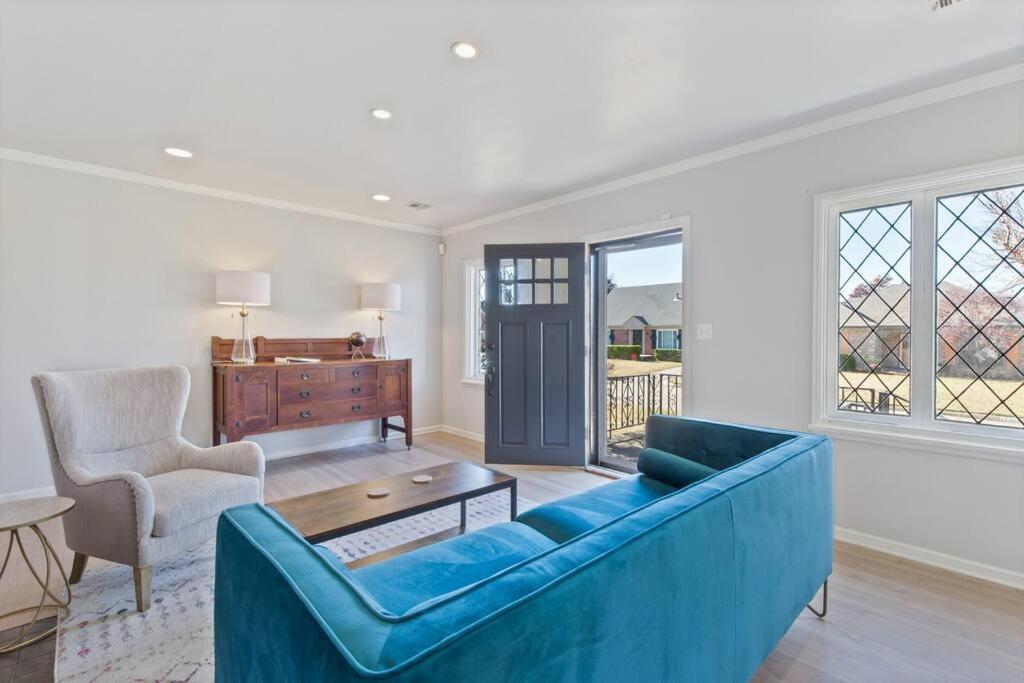 a living room with a blue couch and a table at Vintage Chic Cottage in Tulsa