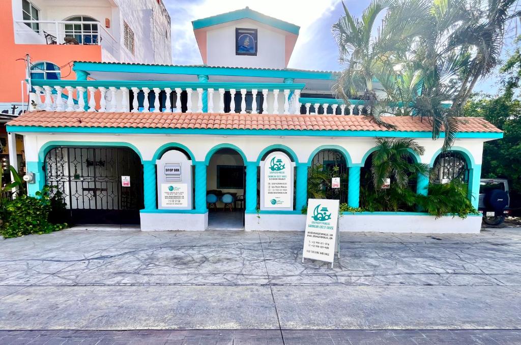 un edificio azul y blanco con un cartel delante en Casa Puerto Morelos, en Puerto Morelos