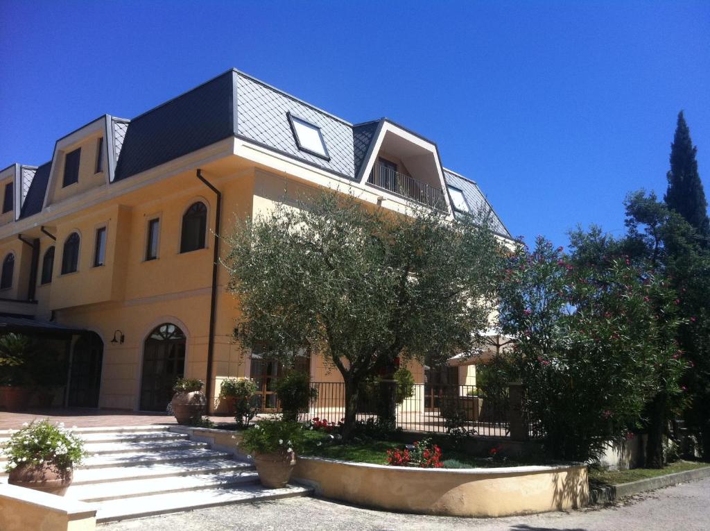 ein großes gelbes Haus mit schwarzem Dach in der Unterkunft Hotel Del Sole in Sora