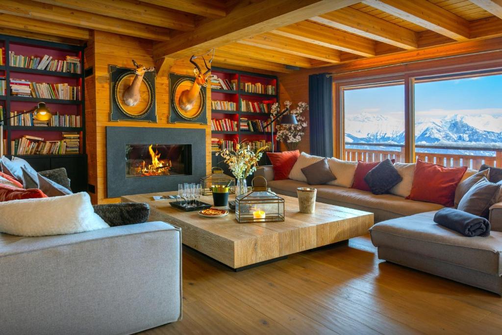 a living room with a couch and a fireplace at Chalet Temaïa - OVO Network in La Toussuire