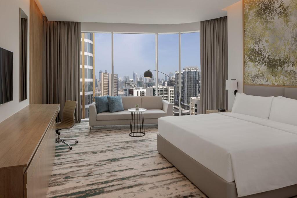 1 dormitorio con 1 cama y sala de estar con vistas. en Holiday Inn Dubai Business Bay, an IHG Hotel, en Dubái