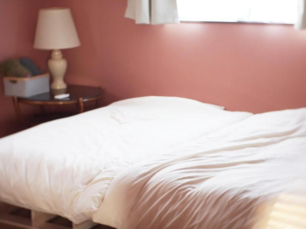 un letto bianco in una camera da letto con una lampada su un tavolo di Goto - House - Vacation STAY 66191v a Goto