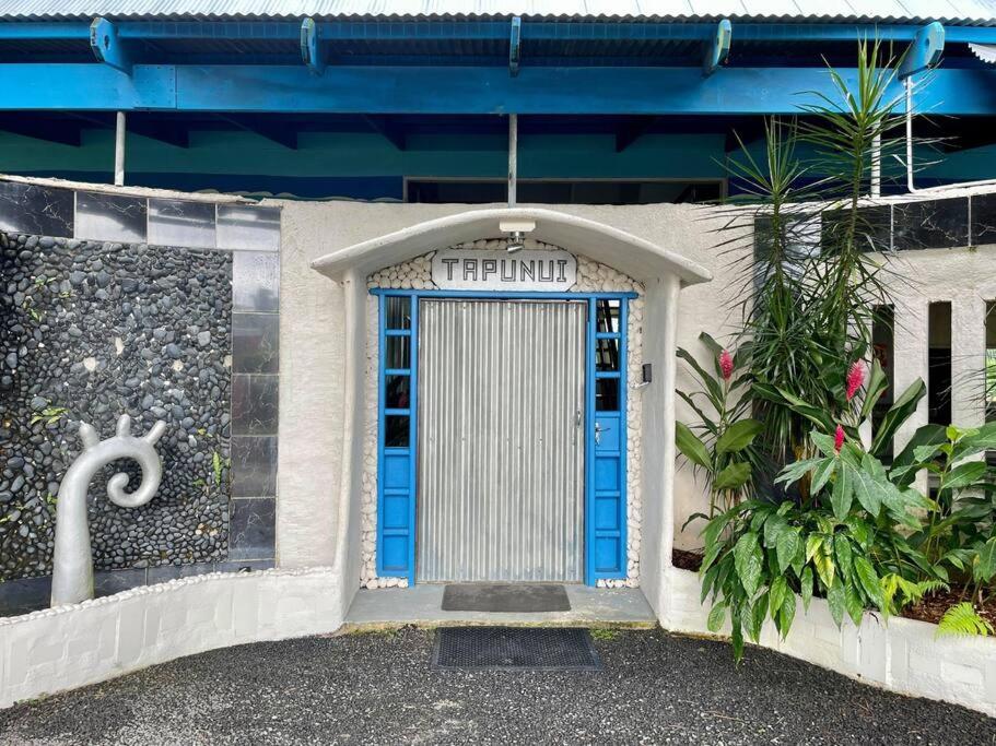 a blue door on a building with a sign above it at Tapunui Spacious Retreat with Superfast Internet in Arorangi