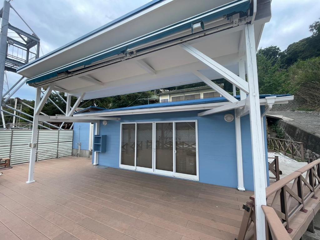 a blue building with awning on a patio at Sea Garden Villa Shodoshima in Kusakabe