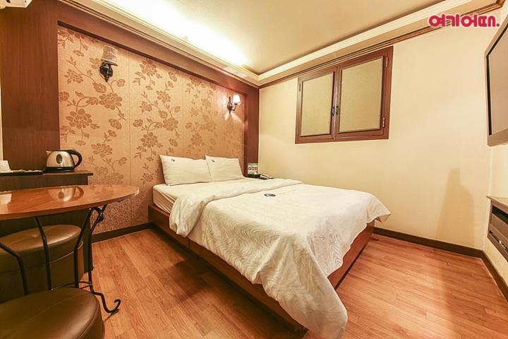 首爾的住宿－Coups Hotel，酒店客房配有一张床、一张书桌和一台电视。